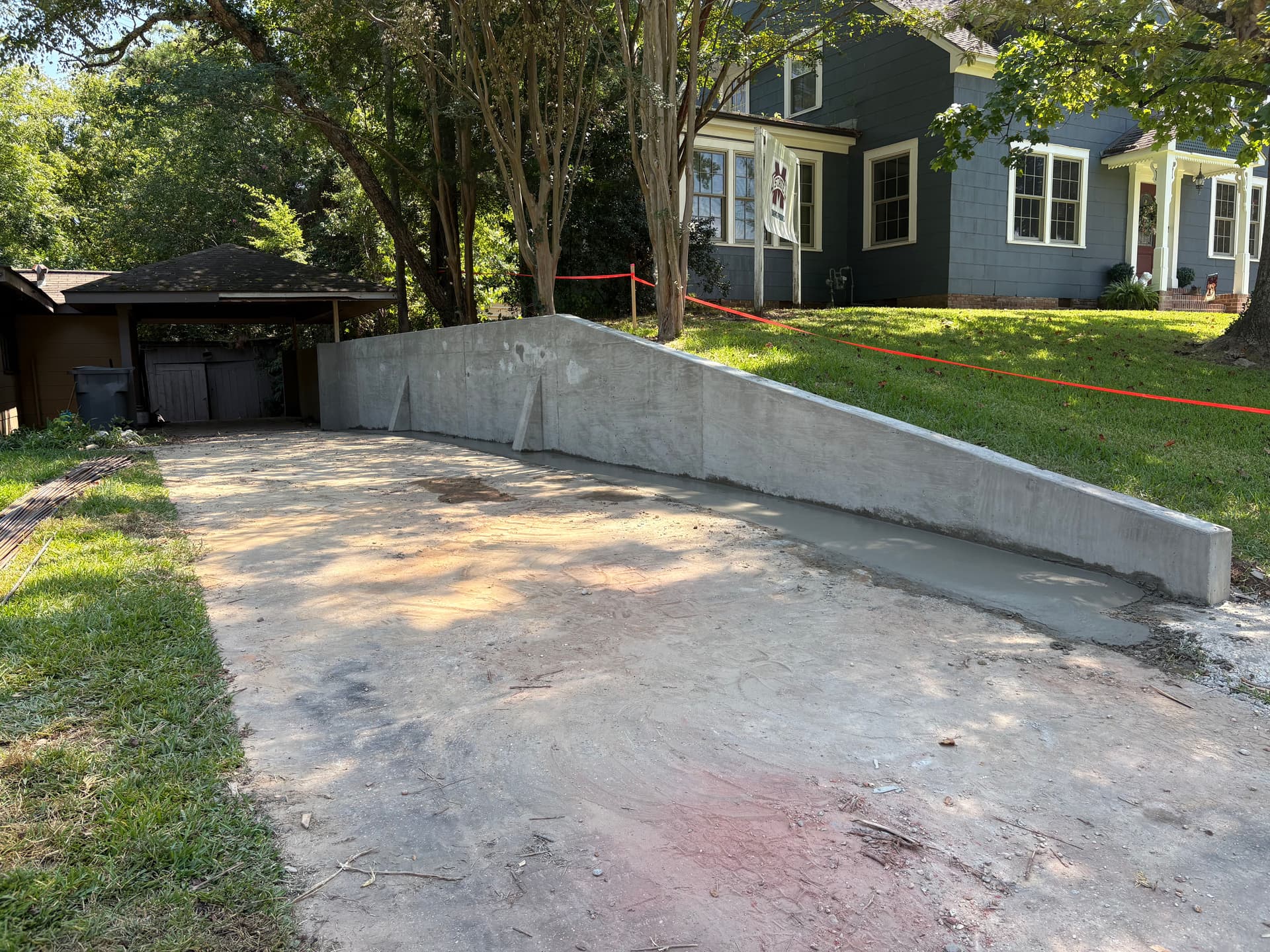 Poured Concrete Retaining Wall Built to Hold Grade Along a Driveway image